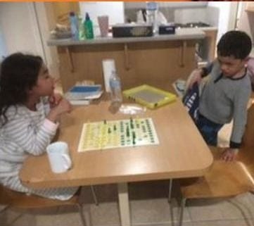 Two children playing Aussie Checkers at a classroom table.